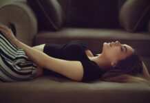 일상을 지배하는 만성피로, 원인과 극복 방법은? woman in black and white stripe shirt lying on brown couch