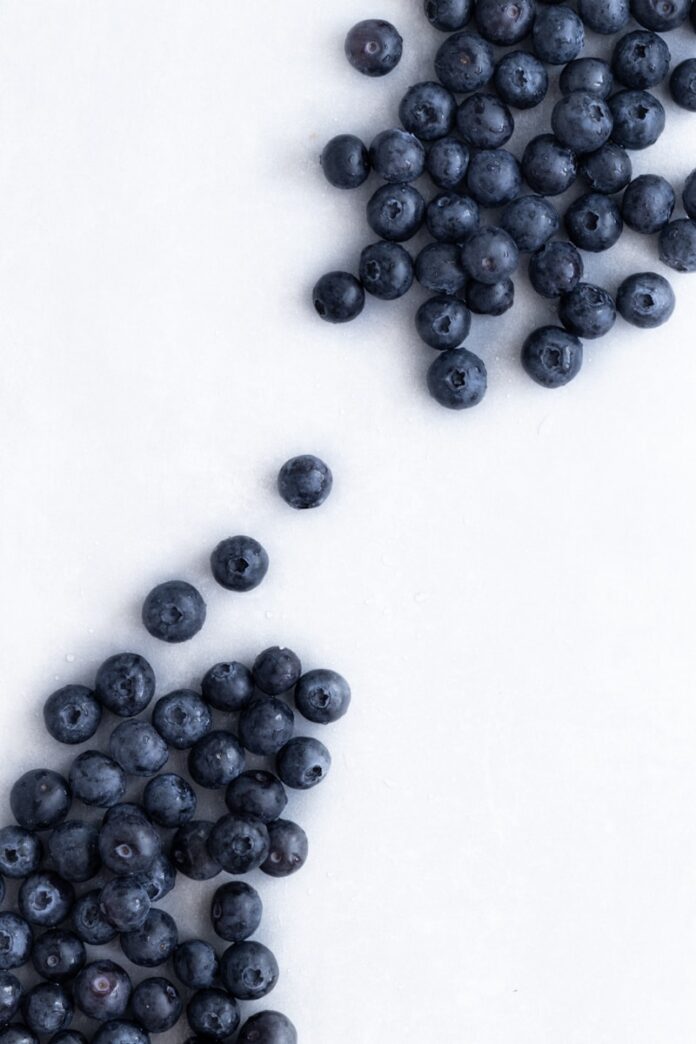 Photo by Nadeykina Evgeniya blue berries on white surface