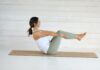 일상 속 필라테스, 내 몸을 깨우는 작은 변화의 시작 Woman in boat pose on yoga mat